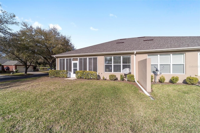 view of front of property with a front yard, roof with shingles, and stucco siding