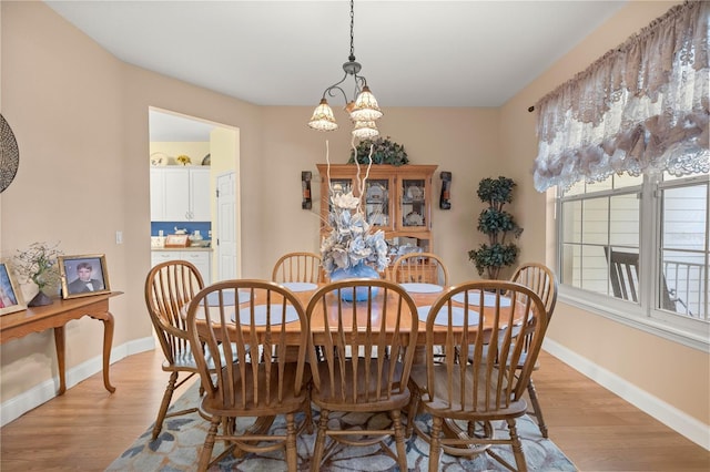 dining room featuring light wood-type flooring and baseboards