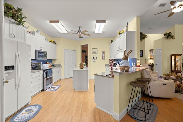 kitchen featuring ceiling fan, appliances with stainless steel finishes, light wood-style flooring, and visible vents