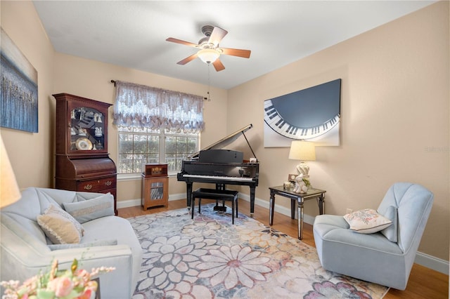 sitting room featuring a ceiling fan, baseboards, and wood finished floors