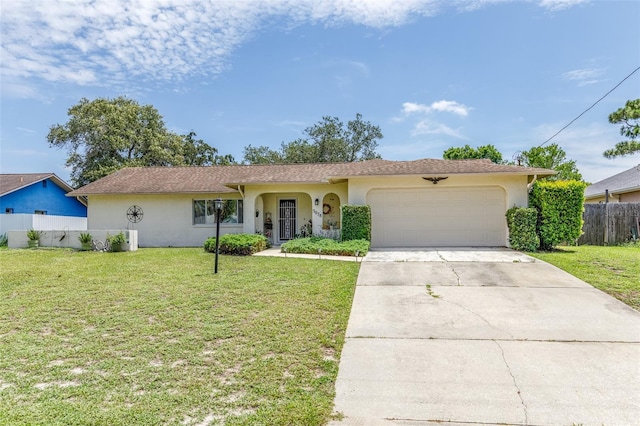 ranch-style home featuring an attached garage, stucco siding, fence, and a front yard