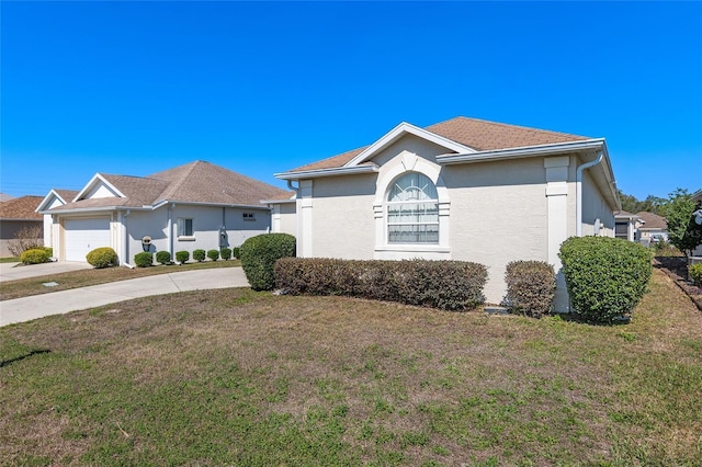 view of side of home with concrete driveway, a lawn, and stucco siding