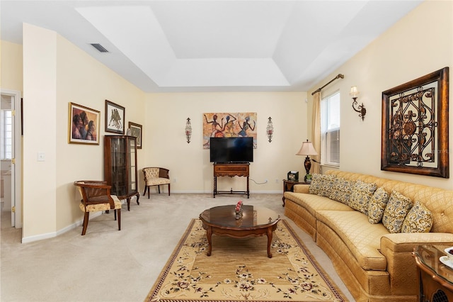 carpeted living room with a tray ceiling, visible vents, and baseboards