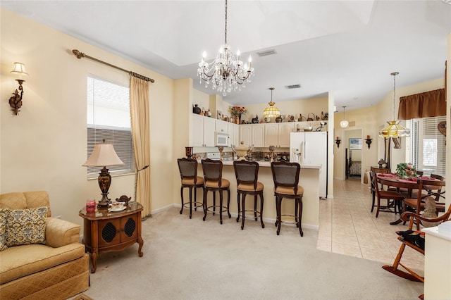 dining room featuring a notable chandelier, light tile patterned floors, visible vents, and light colored carpet