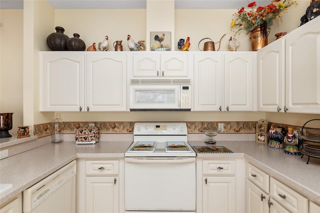 kitchen with light countertops, white appliances, and white cabinetry