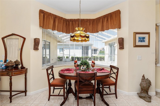 dining space featuring light tile patterned flooring and baseboards