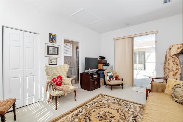 sitting room with carpet floors, attic access, and visible vents