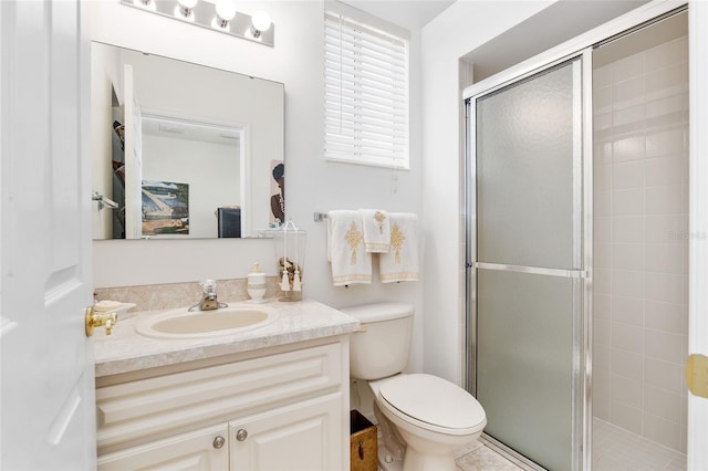 bathroom with toilet, a stall shower, and vanity