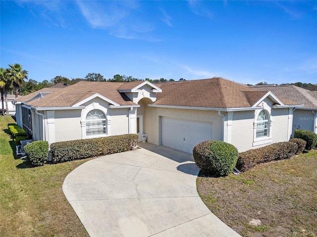 single story home featuring a garage, a shingled roof, concrete driveway, stucco siding, and a front lawn