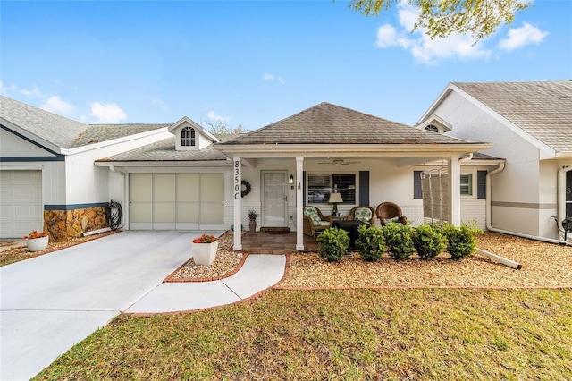 ranch-style home with driveway, a garage, a ceiling fan, roof with shingles, and covered porch