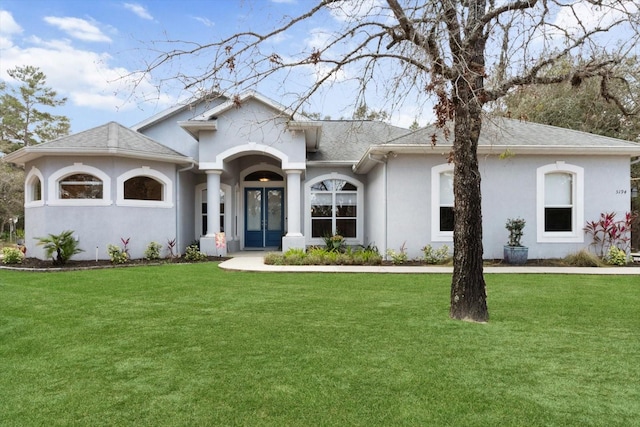 view of front of home featuring french doors, roof with shingles, a front yard, and stucco siding