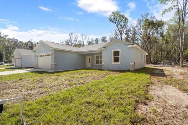 single story home with a garage, concrete driveway, a front lawn, and stucco siding