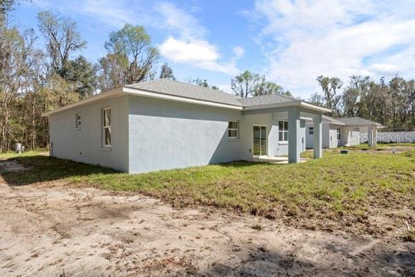 exterior space with a lawn and stucco siding