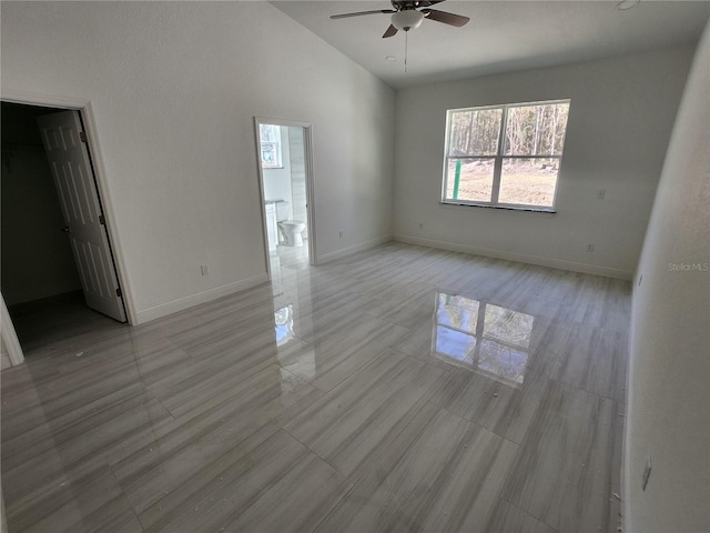 interior space featuring high vaulted ceiling, ceiling fan, and baseboards