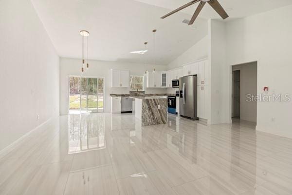kitchen featuring stainless steel appliances, a center island, open floor plan, and white cabinetry