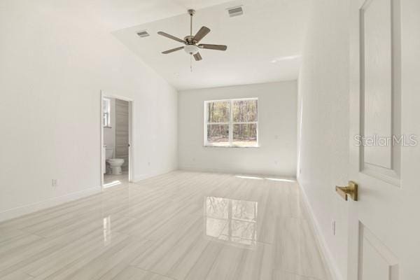unfurnished bedroom featuring ceiling fan, visible vents, vaulted ceiling, and ensuite bathroom