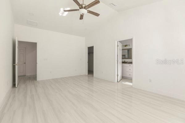 unfurnished room with light wood-style floors, ceiling fan, and high vaulted ceiling