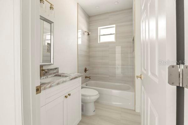 full bath featuring bathing tub / shower combination, vanity, and toilet