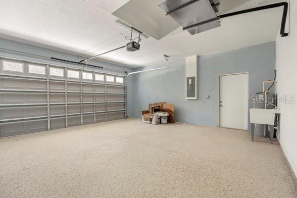 garage with electric panel and a garage door opener