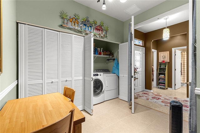 washroom with laundry area, washing machine and dryer, and light tile patterned flooring