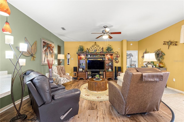 living room with visible vents, baseboards, a ceiling fan, and wood finished floors