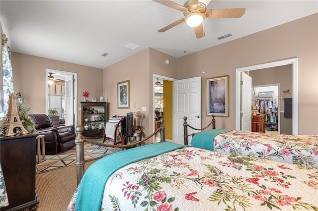 bedroom featuring a walk in closet, visible vents, ceiling fan, and ensuite bathroom