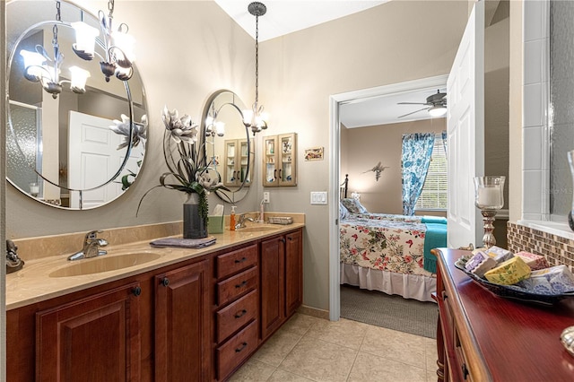 ensuite bathroom with tile patterned flooring, connected bathroom, ceiling fan with notable chandelier, a sink, and double vanity