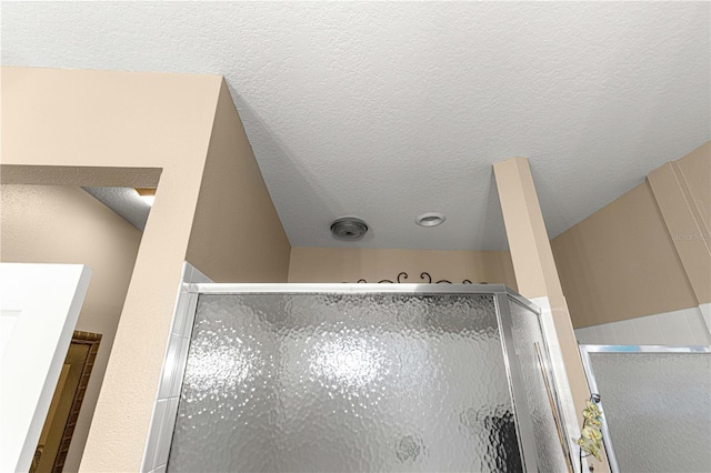 room details with a stall shower and a textured ceiling