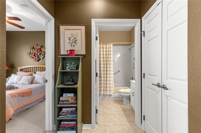 bedroom featuring a ceiling fan, connected bathroom, and light tile patterned flooring