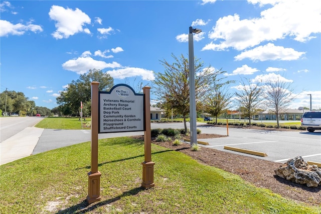 exterior space with uncovered parking and a lawn