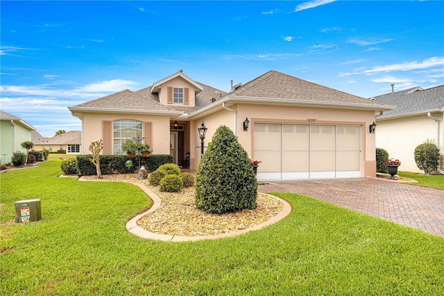 view of front of property with decorative driveway, roof with shingles, stucco siding, an attached garage, and a front lawn