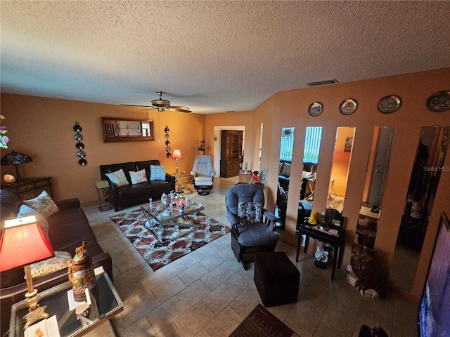 living room with a textured ceiling, ceiling fan, and visible vents