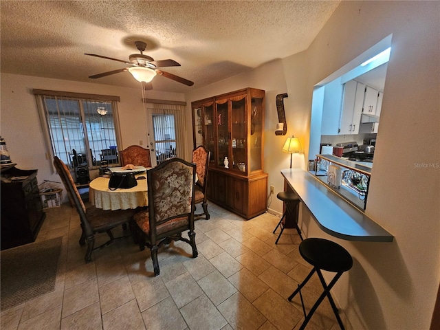 dining room featuring ceiling fan and a textured ceiling