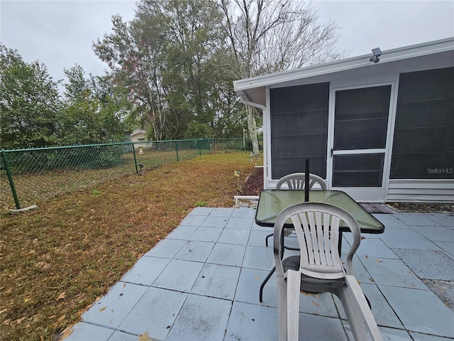 view of patio featuring a sunroom and fence