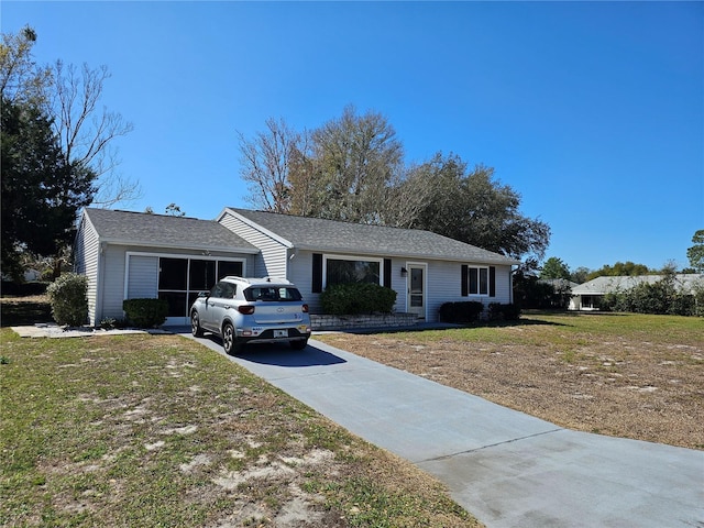 single story home featuring a garage, a front lawn, and concrete driveway