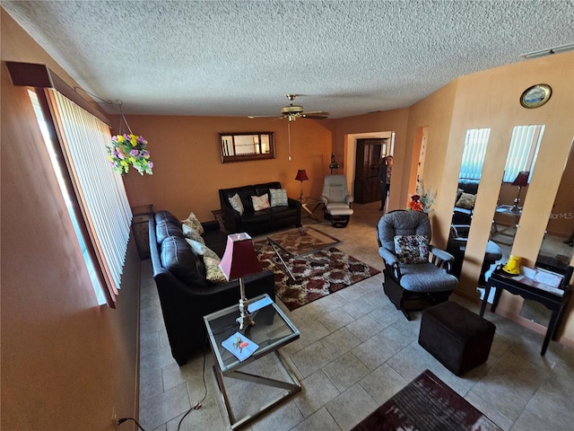 living room with ceiling fan and a textured ceiling