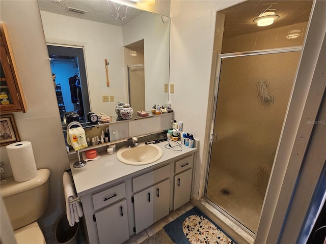 bathroom featuring toilet, a shower stall, visible vents, and vanity