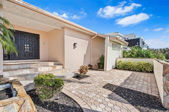 entrance to property with a patio and stucco siding