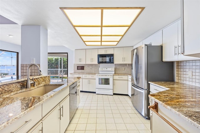 kitchen featuring stainless steel appliances, a sink, decorative backsplash, and light stone counters