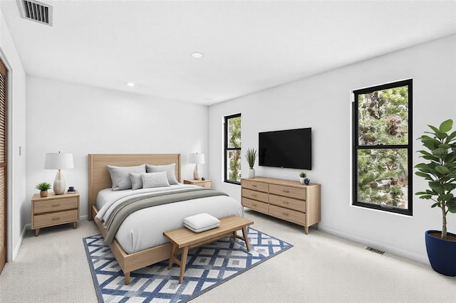 bedroom featuring baseboards, visible vents, and light colored carpet