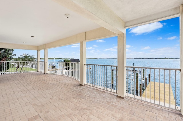 view of patio featuring a water view and a balcony