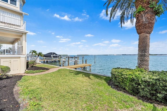 view of dock featuring a water view, a lawn, and boat lift