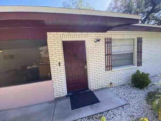 entrance to property featuring brick siding