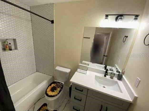 full bath featuring toilet, bathtub / shower combination, and vanity