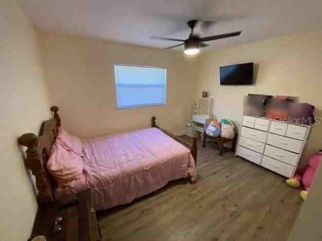 bedroom featuring wood finished floors and a ceiling fan