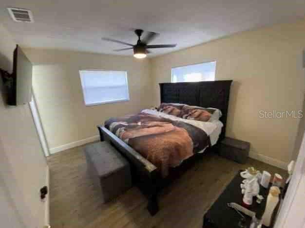 bedroom featuring a ceiling fan, visible vents, and baseboards