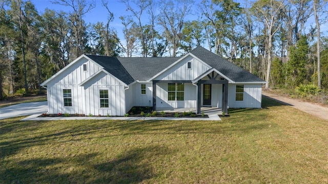 modern farmhouse with covered porch, a front lawn, and board and batten siding