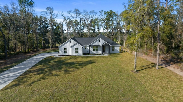 modern farmhouse style home featuring board and batten siding, concrete driveway, covered porch, and a front lawn