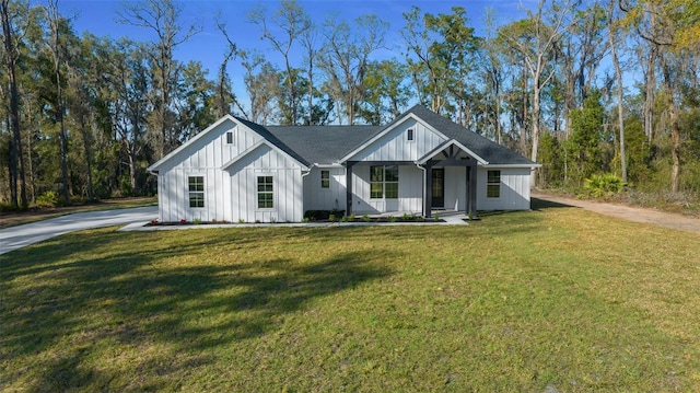 modern inspired farmhouse featuring driveway, board and batten siding, and a front yard