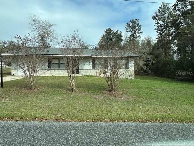 view of front of home with brick siding and a front lawn